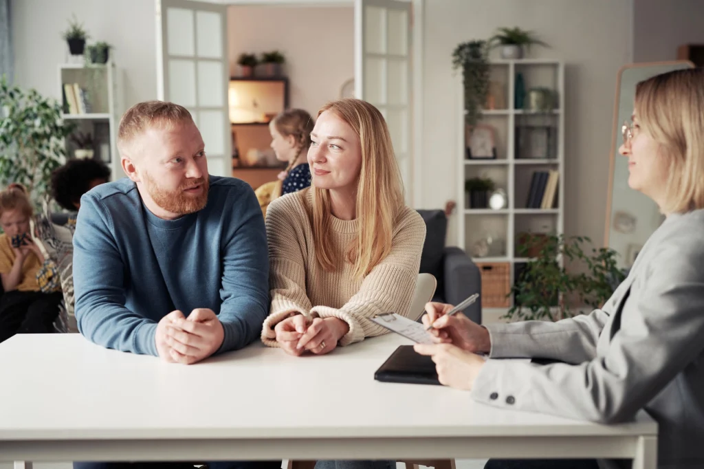 Potential foster parents having a meeting at a desk with an advisor